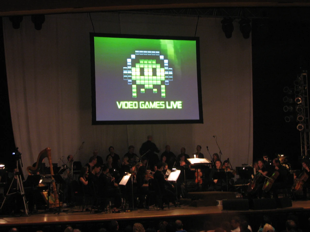 Ein Orchester auf der Bühne, auf der Leinwand ein Pixel-Logo